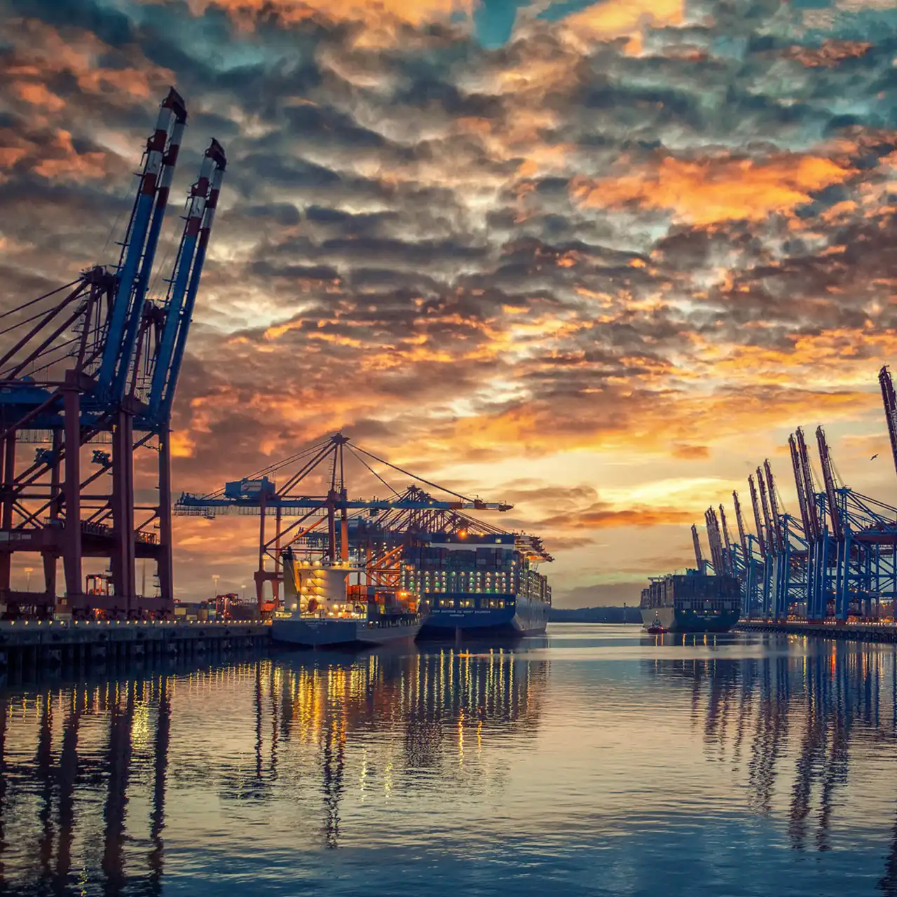 Containerkräne im Hafen bei Sonnenuntergang – angetrieben durch esco-Frequenzumrichter mit Kranfunktion, sicherer Lastregelung und Drehmomentüberwachung.